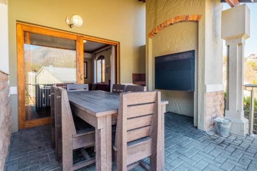 a wooden table and chairs on a patio at ATKV Goudini Spa in Rawsonville