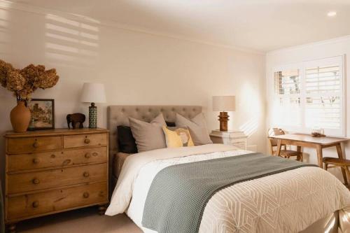 a bedroom with a bed and a dresser and a window at Peony Farm Green Cottage in Stanley