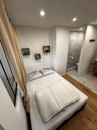 - une chambre avec un lit blanc et une douche dans l'établissement Appartement cosy proche mer calme, à Les Adrets-de-l'Estérel