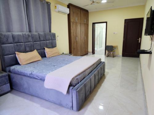 a bedroom with a large blue bed in a room at Jab Villa X in Adentan