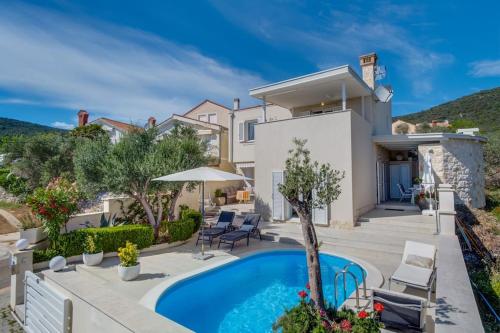 a villa with a swimming pool and a house at Vila Blanka in Martinšćica