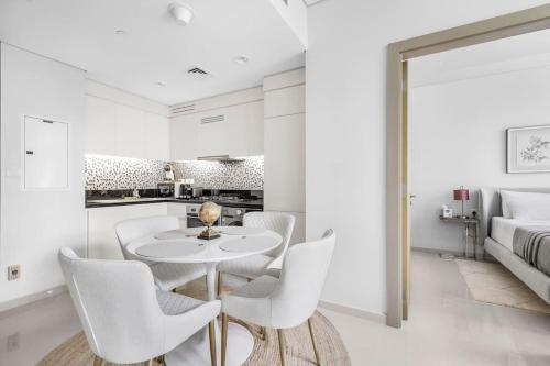 a white dining room with a white table and chairs at Goldbest - Aykon City 2bdr in Dubai