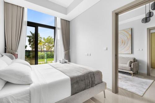 a white bedroom with a large bed and a mirror at Goldbest - Aykon City 2bdr in Dubai