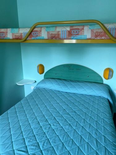 a bed in a room with a blue wall at Europe Hôtel in Varennes Vauzelles