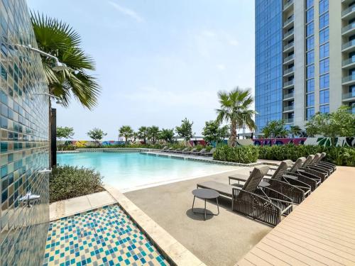 a swimming pool with lounge chairs next to a building at Goldbest - Aykon City 2bdr in Dubai