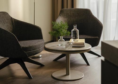 a living room with two chairs and a coffee table at SCHLOSS Zermatt - CBD & Adaptogenic Spa and Sport Hotel in Zermatt