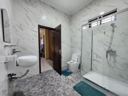 a bathroom with a shower and a sink and a toilet at Jab Villa X in Adentan