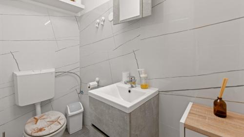 un bagno bianco con lavandino e WC di Villa Zivolic by Villas Holiday a Bičići