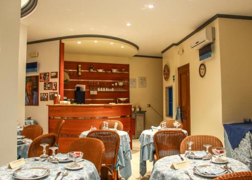 a restaurant with tables and chairs and a counter at Hotel Il Faro Della Guitgia Tommasino in Lampedusa