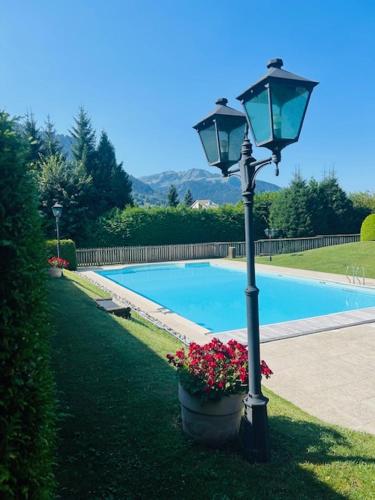 un lampadaire avec des fleurs à côté d'une piscine dans l'établissement Appartement Flocon de Nell, à Megève