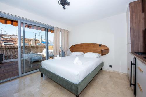 une chambre avec un grand lit et un balcon dans l'établissement Studio Merlot - Welkeys, à Cannes