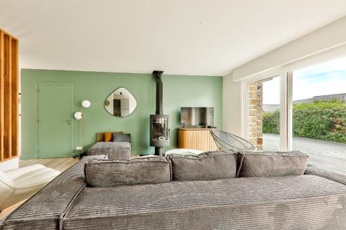 un salon avec un canapé et une cheminée dans l'établissement À 250m de la plage - Grande maison pour 8, à Arzon