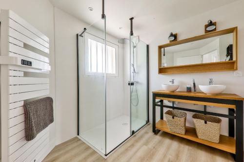 La salle de bains est pourvue d'une douche en verre et de 2 lavabos. dans l'établissement À 250m de la plage - Grande maison pour 8, à Arzon