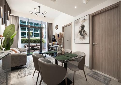 a living room with a glass table and chairs at 1BR Gem with Pool 15 Mins to Downtown Dubai in Dubai