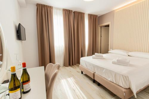 ein Schlafzimmer mit einem Bett und zwei Flaschen Wein in der Unterkunft I Campi Wine Relais in Ronchi