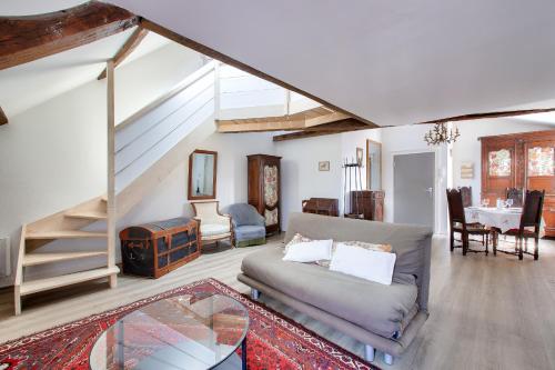 un salon avec un canapé et un escalier dans l'établissement Nantes Mediathèque, grand T2 sous les toits, à Nantes