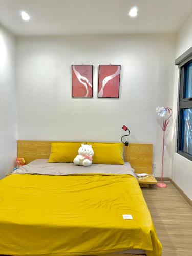 een geel bed met een teddybeer erop bij AN Homes in Hanoi
