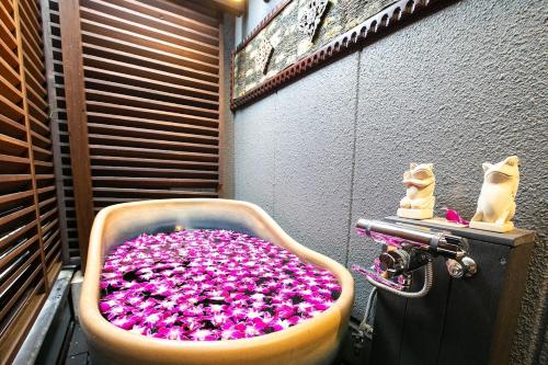 a bath tub filled with lots of pink flowers at Hotel Balian Resort Higashi Shinjuku in Tokyo
