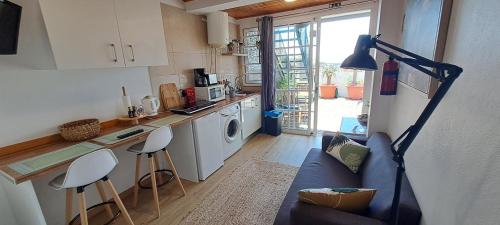 a living room with a couch and a kitchen at Madeira Holiday Flats in Funchal