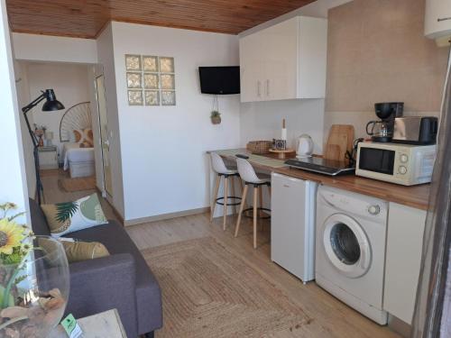 a kitchen and living room with a microwave and a washing machine at Madeira Holiday Flats in Funchal