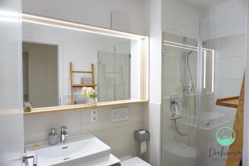 a bathroom with a sink and a shower with a mirror at Dahoam am Samerberg in Samerberg