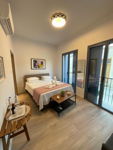 a bedroom with a large bed and a table at Le Voyageur By the Sea - Furnished Rooms in Larnaka