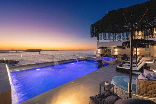 a swimming pool with a view of the ocean at night at Elia Sea Suites in Chania Town