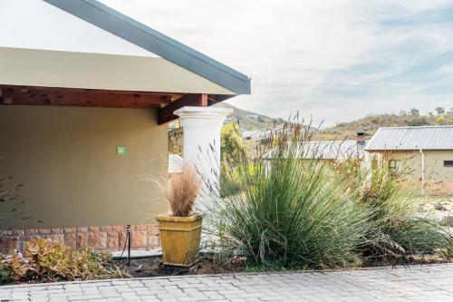 a porch of a house with a pillar and plants at ATKV Goudini Spa in Rawsonville