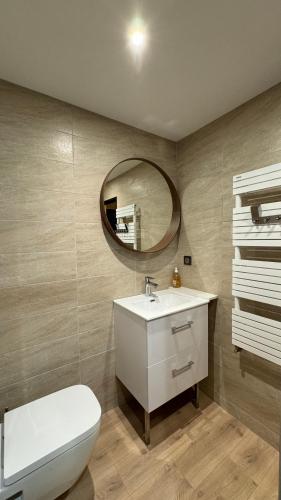 une salle de bain avec des toilettes blanches et un miroir dans l'établissement Appartement Résidence Ourse Bleue, à Courchevel