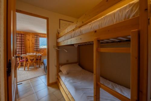 - une chambre avec 2 lits superposés et une salle à manger dans l'établissement Apartment Eterlou - Snow and Trek, à Morzine