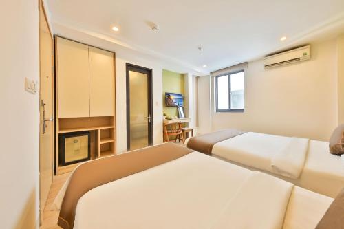 a hotel room with two beds and a fireplace at Daisy Flower Nha Trang in Nha Trang