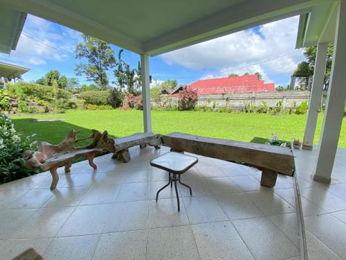 a bench in a room with a view of a field at Super Wonderful 5 bedrooms with Bathroom Villa Marion Tomohon in Tomohon