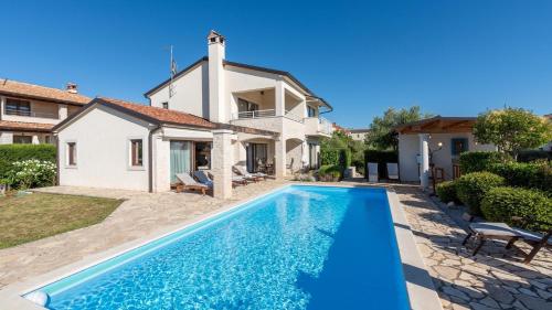 a villa with a swimming pool in front of a house at Villa Nira by Villas Holiday in Barat