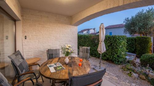 a patio with a wooden table and chairs and an umbrella at Villa Nira by Villas Holiday in Barat