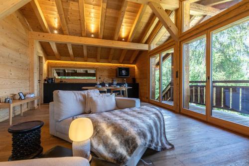 a living room with a couch and some windows at Base Camp COSY chalet 4 personnes in Les Mosses