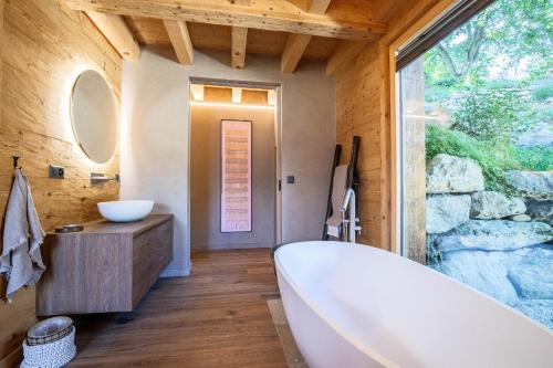 a bathroom with a tub and a large window at Base Camp COSY chalet 4 personnes in Les Mosses