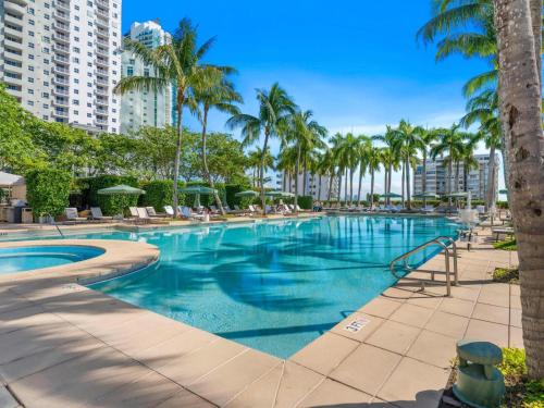 a large swimming pool with palm trees and buildings at Casiola Residences at Four Seasons Miami Brickell in Miami