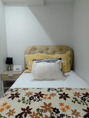 a bed with a blanket and pillows on it at Jojies Crib Horizons101 Studio in Cebu City