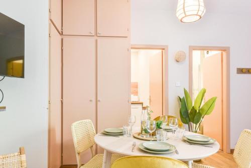 une salle à manger avec une table et des chaises blanches dans l'établissement L'escale - proche Homme de Fer, à Strasbourg