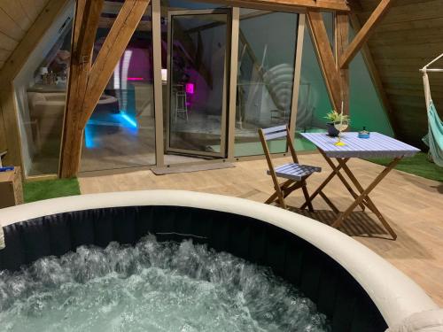 - un bain à remous au milieu d'une maison avec une table dans l'établissement Nid de cigogne, à Illhaeusern