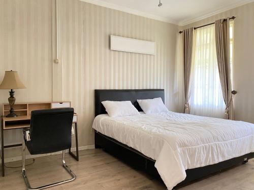 a bedroom with a bed and a desk and a chair at Super Wonderful 5 bedrooms with Bathroom Villa Marion Tomohon in Tomohon