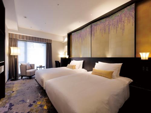two beds in a hotel room with a large wall at THE HOTEL SANRAKU KANAZAWA 21th December 2022 OPEN in Kanazawa