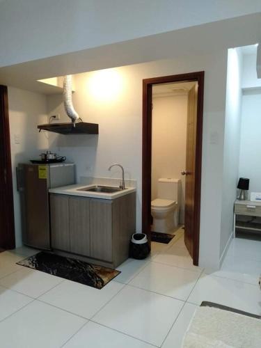 a kitchen with a sink and a toilet in a room at Jojies Crib Horizons101 Studio in Cebu City