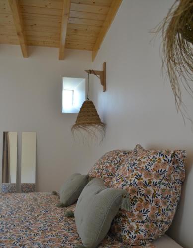 a bedroom with a couch with pillows on it at La métairie du rumain in Troguéry