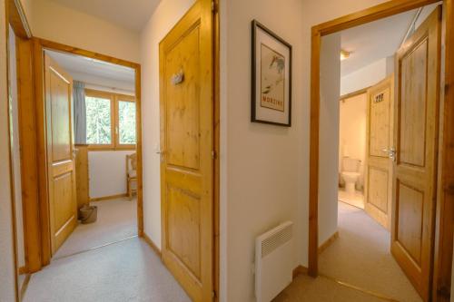 un couloir avec deux portes et une salle de bains. dans l'établissement Chalets de Nyon - Snow and Trek, à Morzine