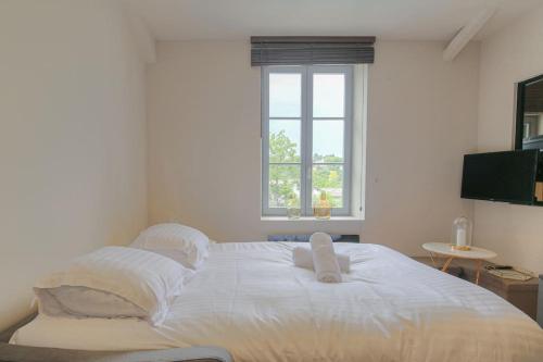 un grand lit blanc dans une chambre avec une fenêtre dans l'établissement Joli T1 pour 4, Champagne, Monts d'Or, Lyon, à Champagne-au-Mont-dʼOr