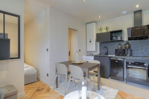 une cuisine avec une table et des chaises dans une pièce dans l'établissement Joli T1 pour 4, Champagne, Monts d'Or, Lyon, à Champagne-au-Mont-dʼOr