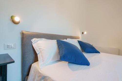 a bed with blue and white pillows on it at Guest House Deidda - TS ROOMS B&B in San Sperate