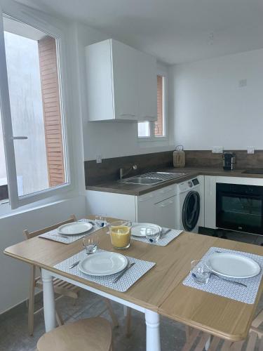 une cuisine avec une table avec deux assiettes dessus dans l'établissement T2 rénové avec terrasse au cœur des Cévennes, à Saint-Germain-de-Calberte