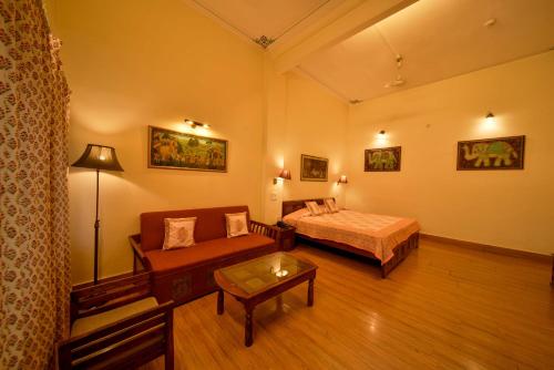 a hotel room with a bed and a couch at Hotel Arya Niwas in Jaipur